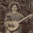 A young man with a banjo and a kitten